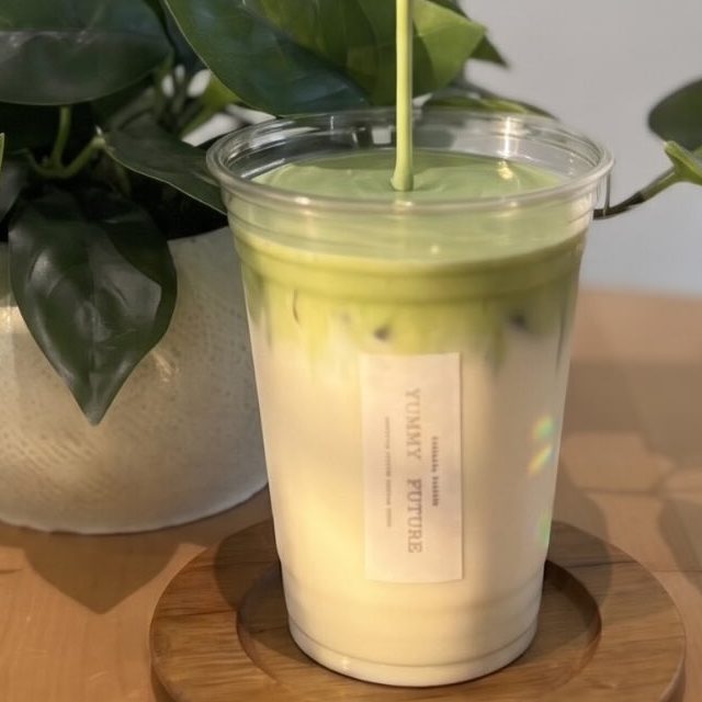 Matcha poured over jasmine tea latte in a clear cup