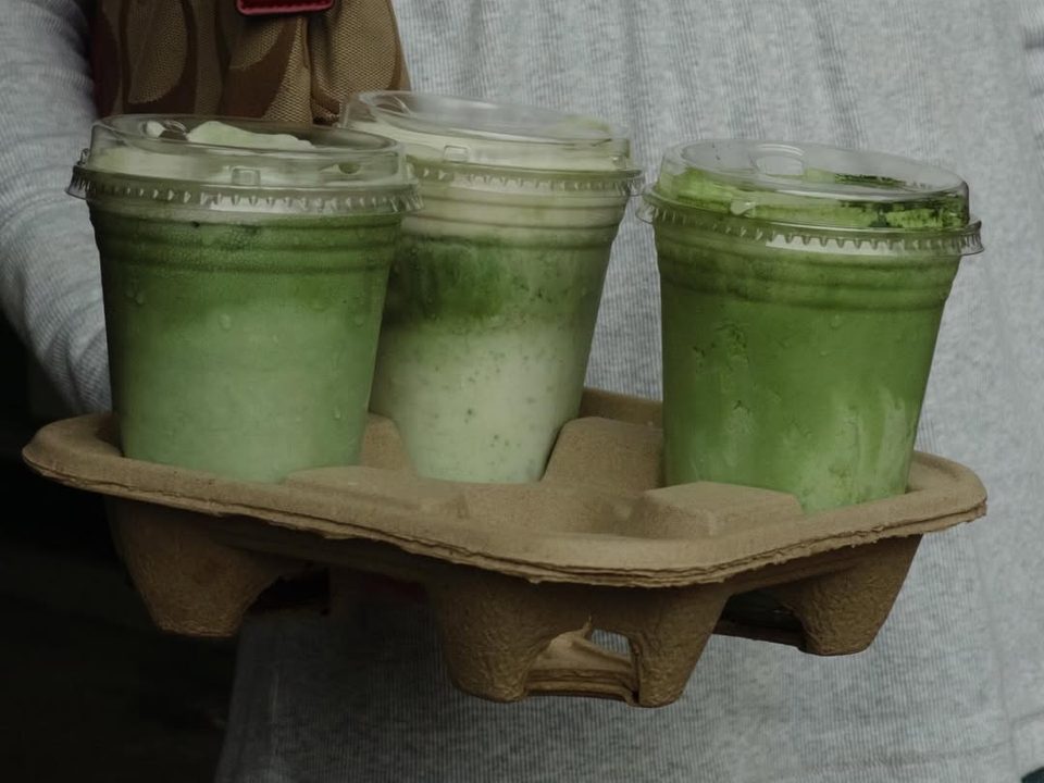 Three iced matcha drinks in a paper carrier